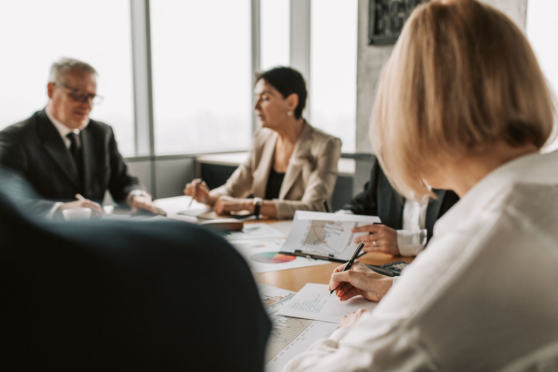 A formal board meeting with people seated around the table
